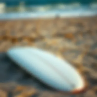 A well-maintained used surfboard resting on the sand