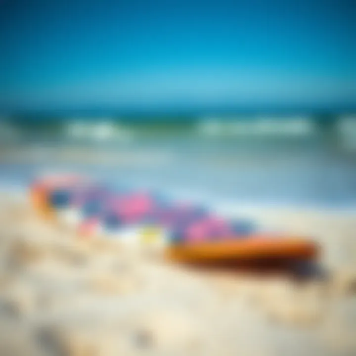 A close-up of a surfboard with vibrant designs resting on the sandy beach