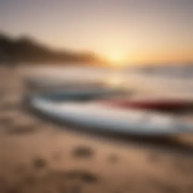 Close-up of surfboards lined up on the beach at dawn