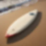 A vintage single fin surfboard resting on the sand, showcasing its classic design.