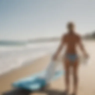 A surfer using a changing towel for privacy on the beach