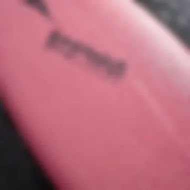 A close-up of a pink Surftech surfboard showcasing its innovative design and craftsmanship